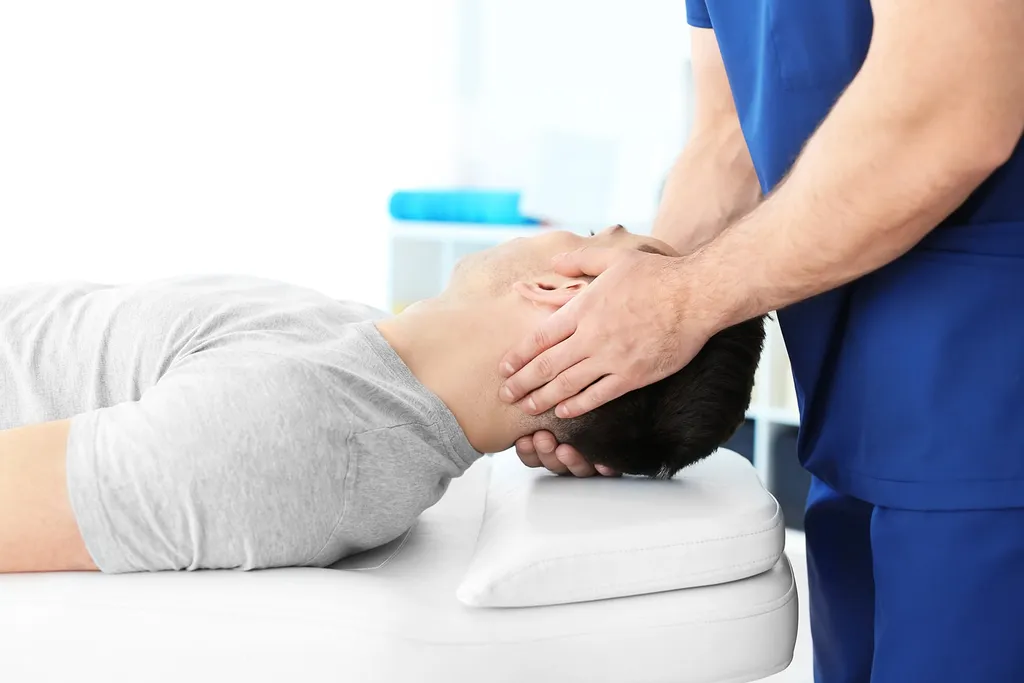 Clinician working with a patient on balance retraining as part of vestibular rehabilitation