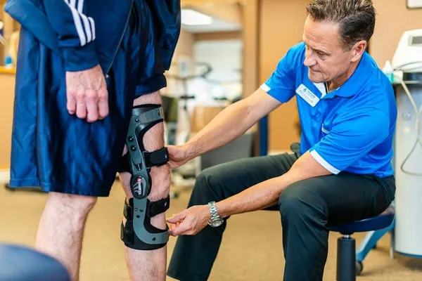 Custom-fit knee brace being adjusted on a patient at the clinic